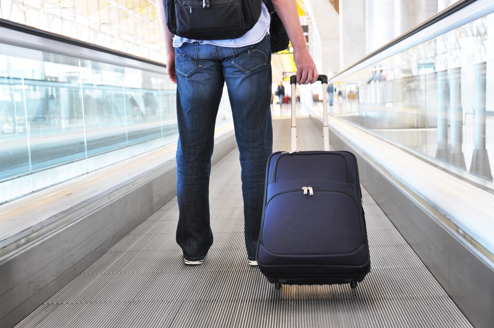 Mand med kuffert i lufthavn